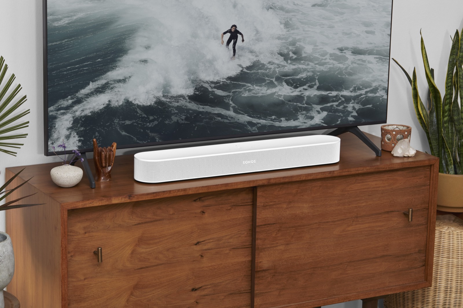 Soundbar on a wooden media console beneath a large wall TV
