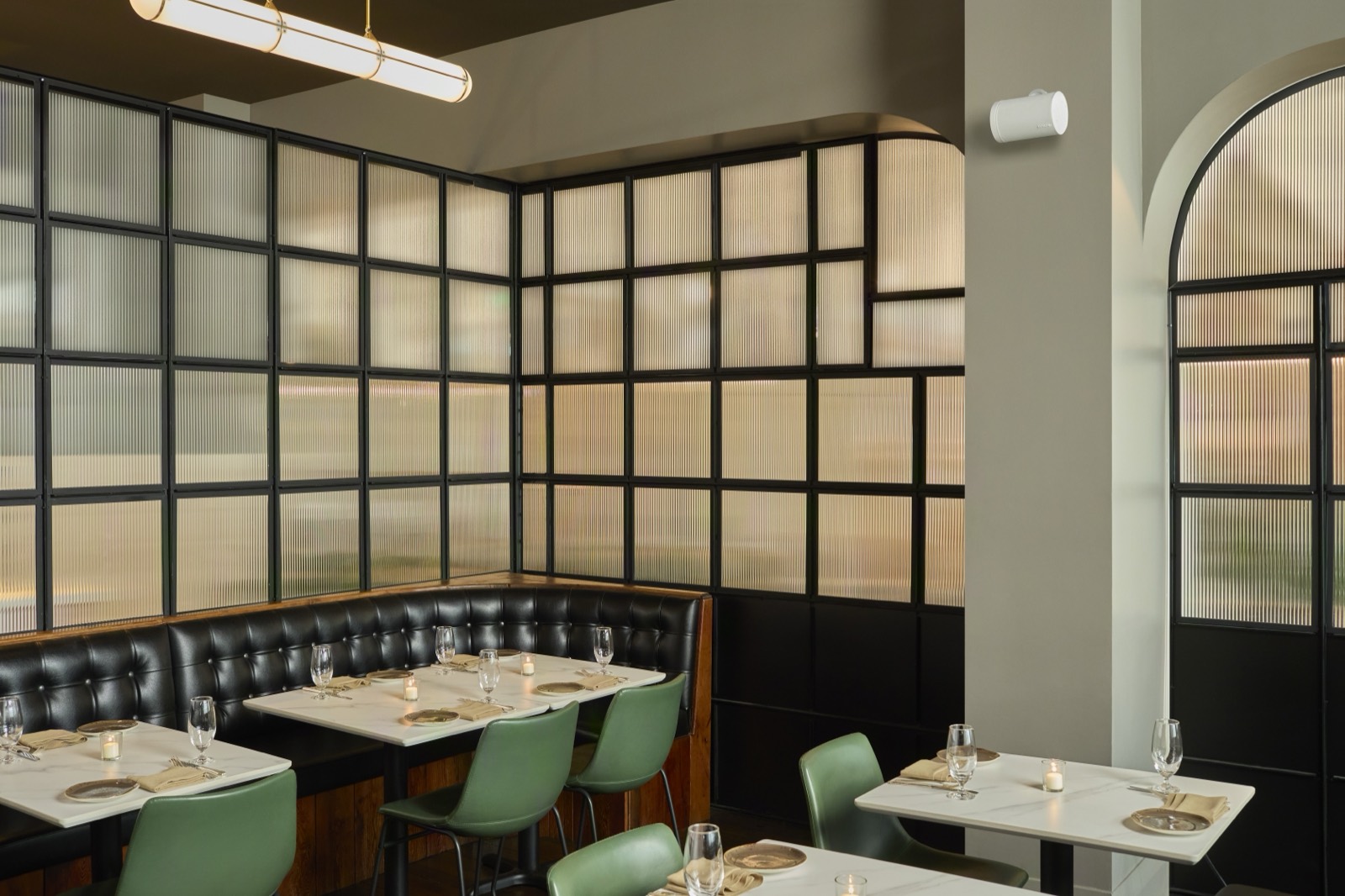 Restaurant dining room with a wall-mounted commercial speaker